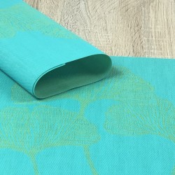 Reverse side of vibrant green Verdigris woven vinyl tablemats rolled up in focus