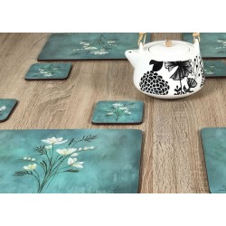 Wooden table with close up of teapot and Infinity, teal blue background, corkbacked floral placemats